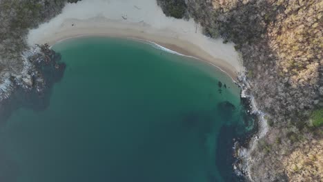 Drone-footage-showcasing-Bahía-El-Organo-at-sunset-in-Huatulco,-Oaxaca