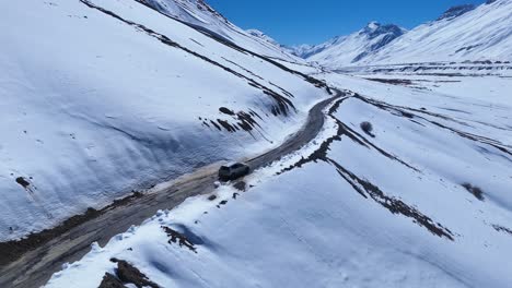snowy mountain road with vehicle