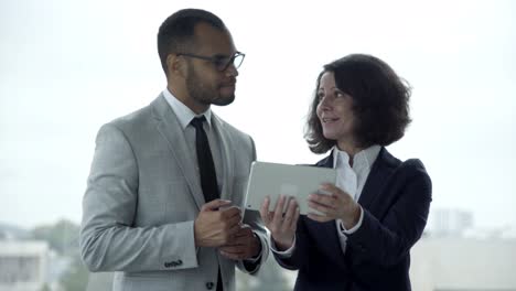 smiling people wearing formal wear using tablet