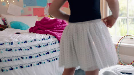 happy teenage girl dancing in bedroom wearing ballet tutu having fun practicing dance moves at home