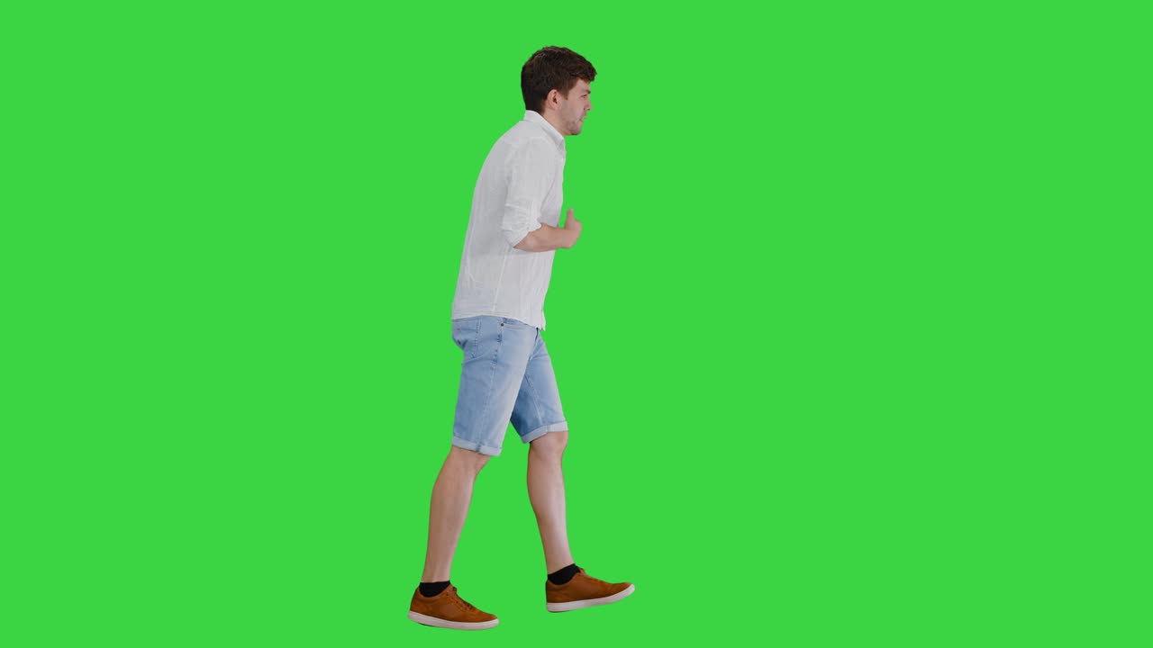 녹색 스크린, 크로마 키에서 여름 열에 시달리는 동안 고 그의 셔츠를 만지는 지친 젊은 남자