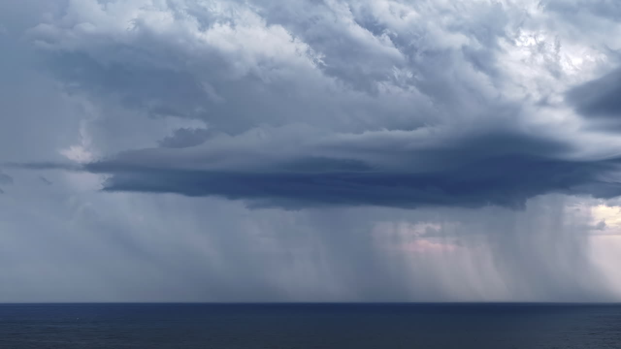 Aerial time lapse captures a powerful rainstorm and thunderstorm above the Baltic Sea, showcasing dramatic clouds, rainfall, and flashes of lightning over the water
