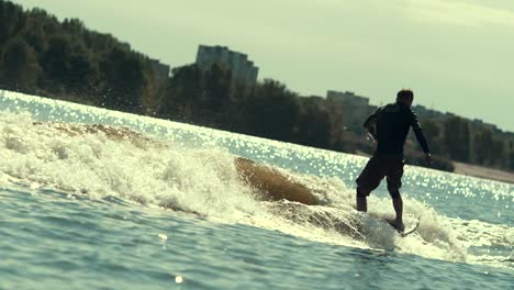 athletic man wake surfing on waves. wake boarding sport. extreme holidays