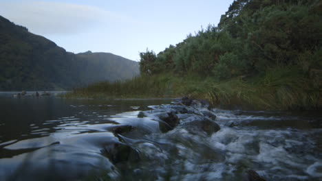 a small waterfall in a scenic lake in glendalough ireland