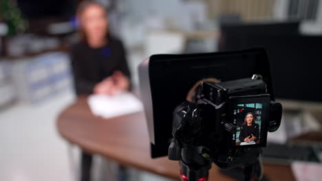 Modern camera with a display recording a speech of a Caucasian brunette. Blogger shooting content for blog. Close up.