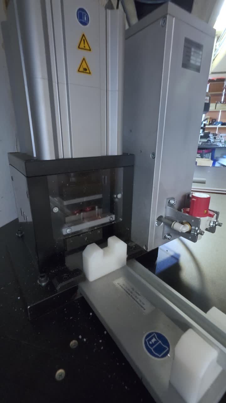 Cutting Metal Bar With Modern Cutting Machine At Workshop. closeup, vertical shot