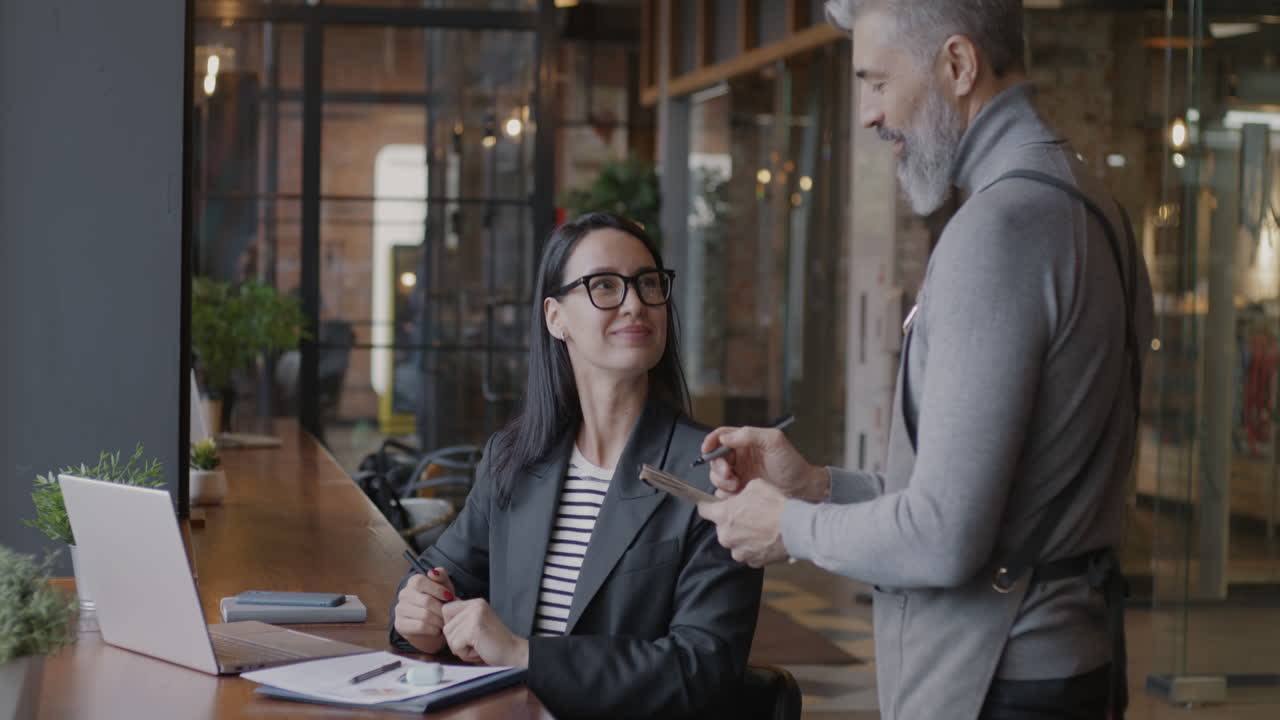 Businesswoman and Waiter in Cafe