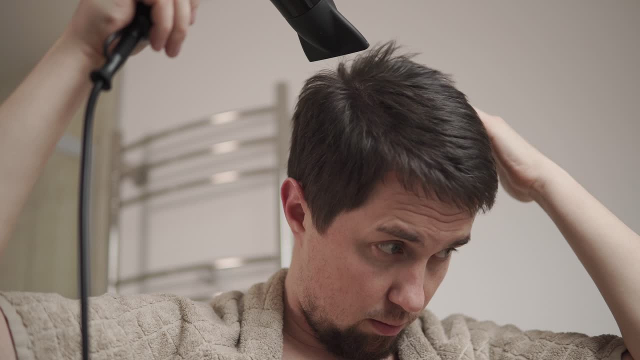 남자 가 화장실 에서 머리 를 건조 시키고 있다