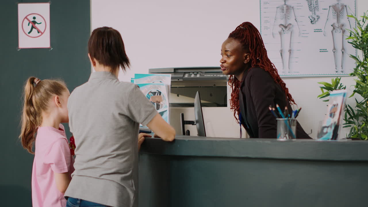 African american receptionist giving assistance to mother and kid