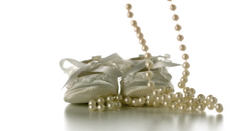 pearl necklace falling onto baby shoes