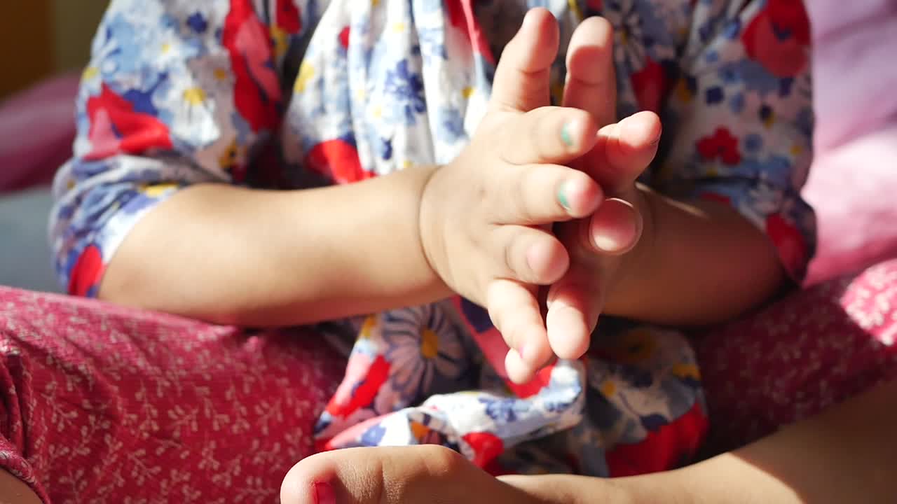 adorable niña con uñas pintadas jugando