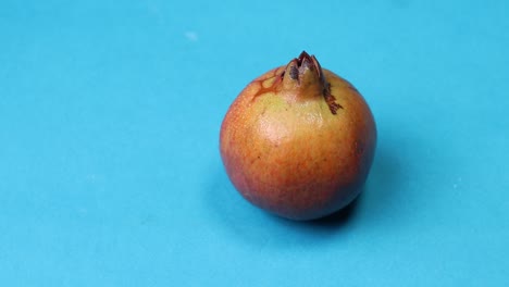 Ein-Reifer-Roter-Granatapfel-Auf-Blauem-Hintergrund