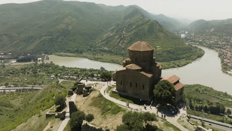 people outside the famous jvari monastery on mountaintop with overview of rivers aragvi and mtkvari in mtskheta town, georgia