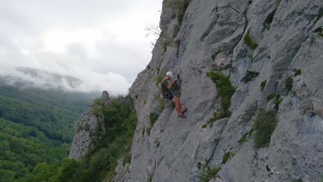 Nahe-Drohnenaufnahmen-Eines-Mannes,-Der-Beim-Vorstieg-Absteigt-Und-Die-Kamera-In-Den-Pyrenäen-Bei-Tarascon-Sur-Ariège-Beobachtet