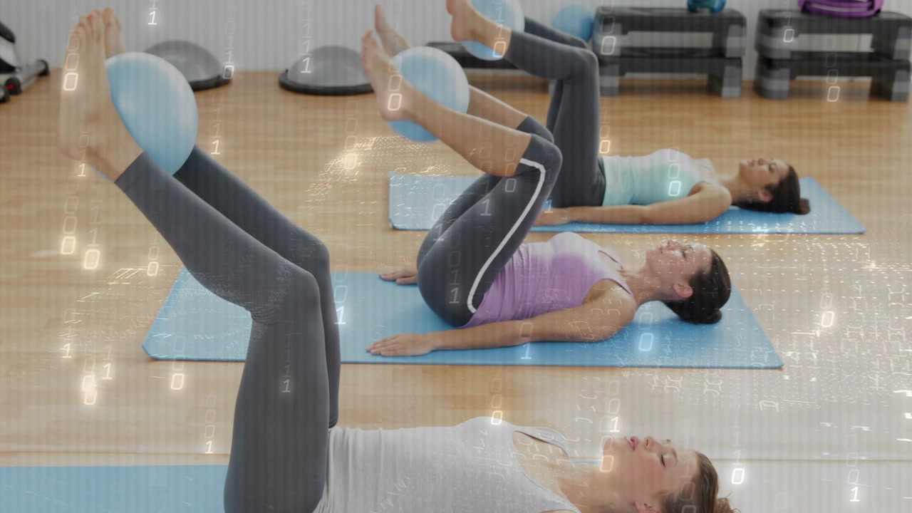 Three women lying supine on mats squeezing small ball, lifting legs and lowering for Pilates toning