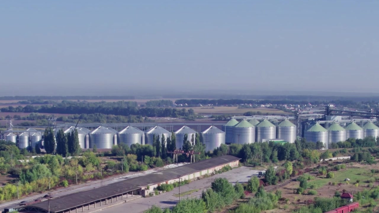 Landwirtschaftliche Lagergebäude mit Silos nahe Feldern im Sommer.