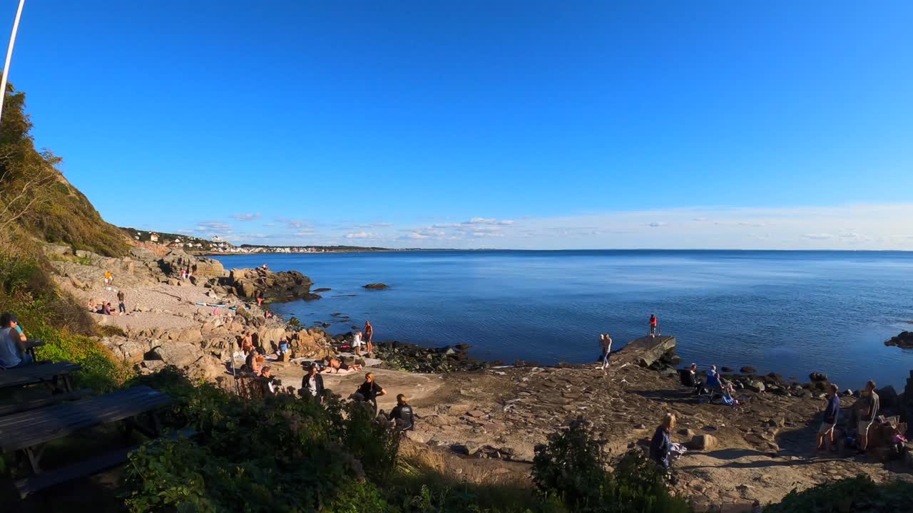 스웨덴 몰레에 있는 ransvik havsveranda 레스토랑의 타임랩스와 해변에 있는 일부 사람들