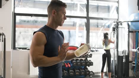 man drinking protein shake in gym