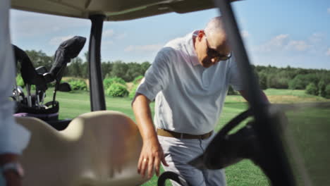 dos jugadores sentados en un carrito de golf en un fin de semana de verano activo.
