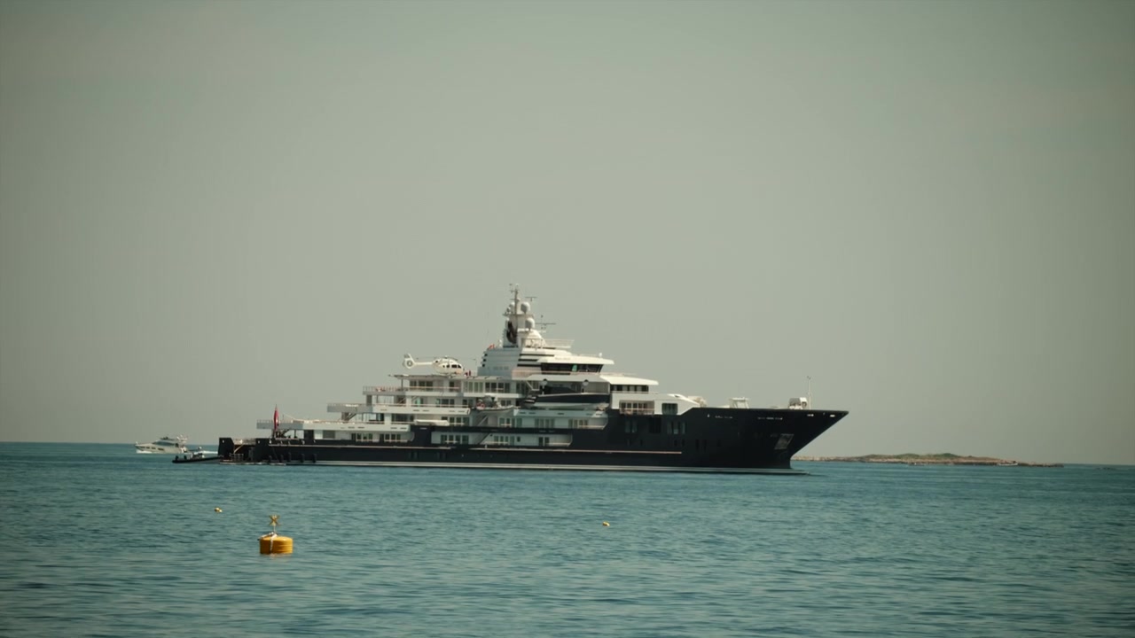 Superyacht di lusso che galleggia su un mare turchese, rappresentando ricchezza, viaggi e uno stile di vita di lusso. Cielo limpido e luminoso sopra.