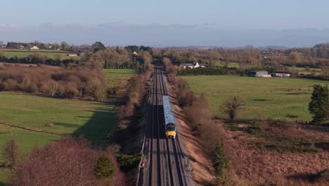 irish train crossing green fields in county kildare, calm rural landscape, travel vibe
