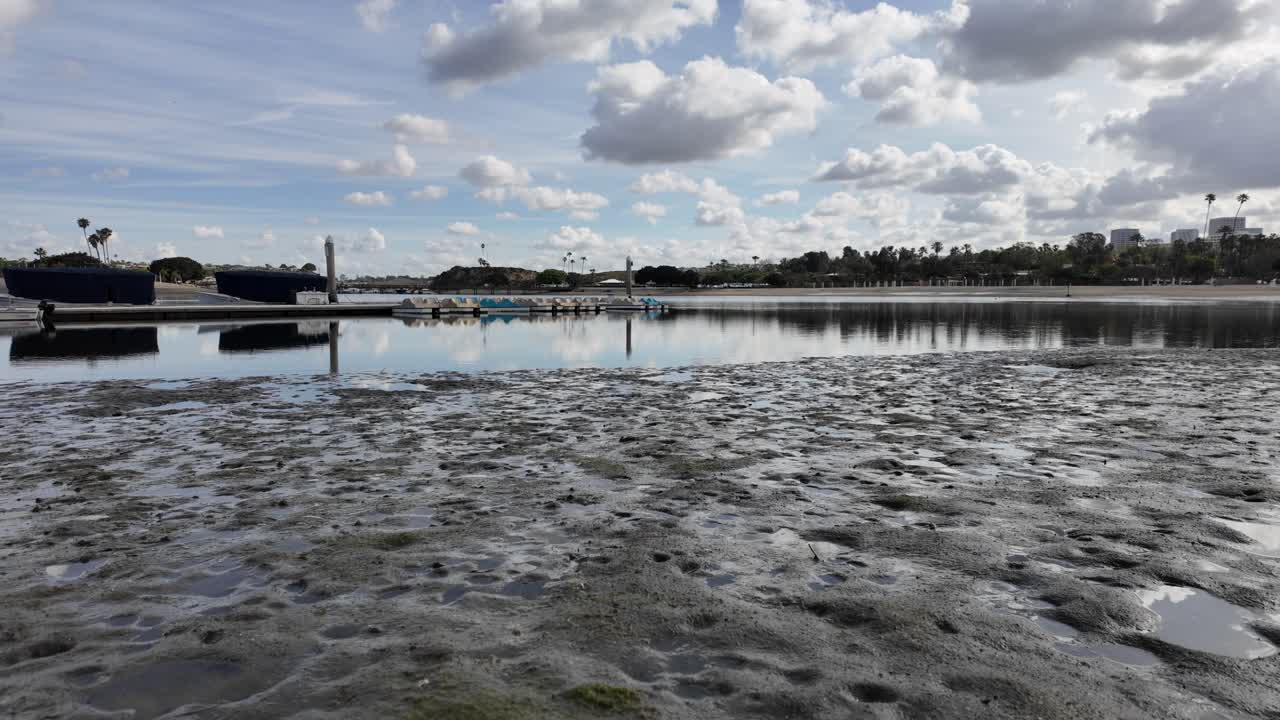 Ujęcie na wysokości oczu przedstawiające plażę z zachmurzonym niebem i spokojną nadmorską atmosferą.