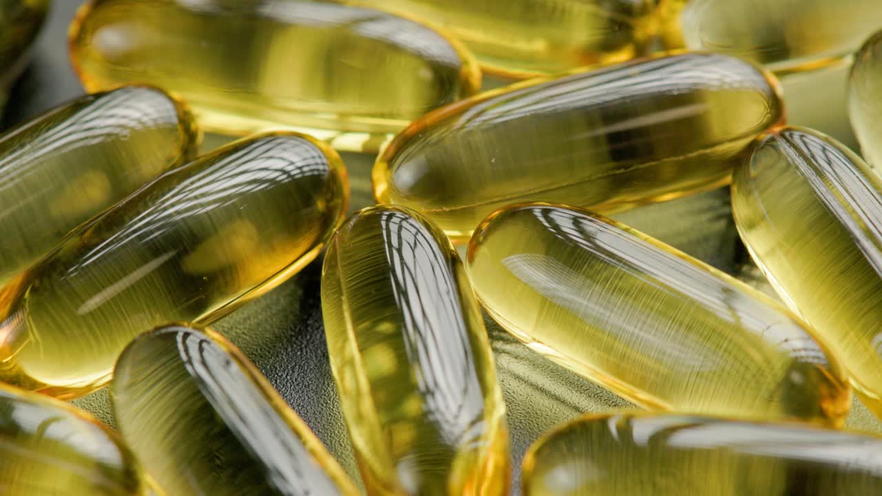 pastillas transparentes doradas con medicamento líquido giratorio, primer plano de cuadro completo