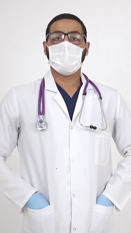 mature female doctor in white uniform holding a bottle of pills working in medical office.