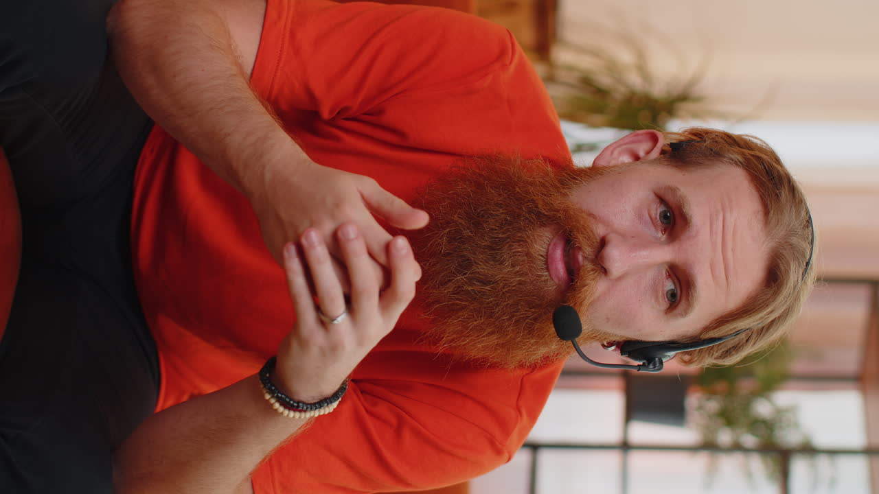 hombre barbudo trabajador independiente centro de llamadas, operador de servicio de apoyo línea de ayuda hablando con el cliente