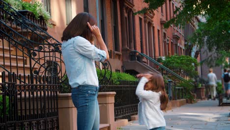 Young-mother-and-daughter-playing-in-the-street,-Brooklyn