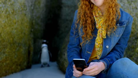 mujer usando teléfono móvil en la playa 4k