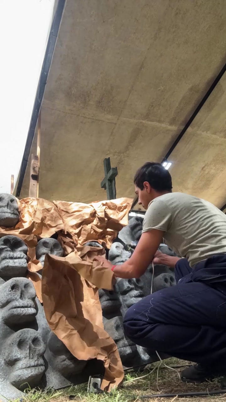 Craftsman creating stone wall art in outdoor workshop, timelapse