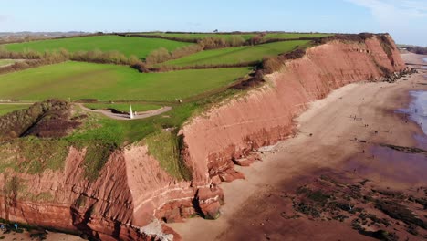Aerial-Of-Orcombe-Cliffs-Coastline-In-Exmouth-With-Visitors-On-Beach-On-Sunny-Day