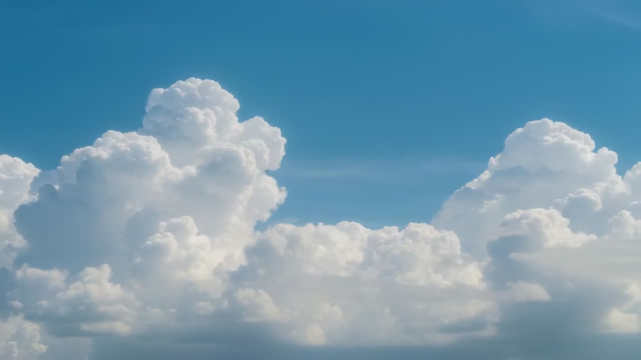 Expanding cumulus clouds merging into cumulonimbus towers over blue sky signaling approaching storm