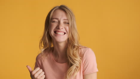 caucasian woman celebrating and keeping thumb up on camera.