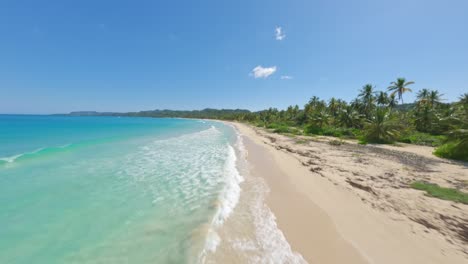 Vuelo-De-Drones-Fpv-A-Lo-Largo-De-Una-Playa-De-Arena-Con-Agua-Transparente