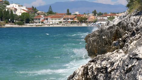 foamy waves of the ionian sea crash against a rocky cliff on corfu island