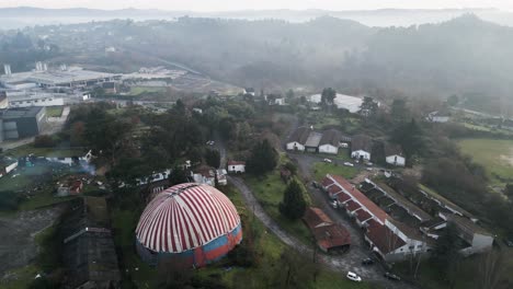 drone trucking pan to reveal settlement homes below benposta circus tent