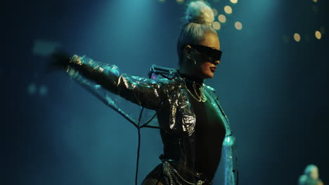 a young woman with blonde hair and sunglasses dances on stage