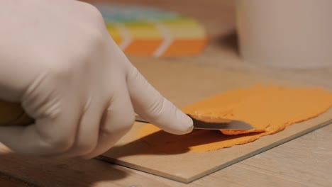 a worker applies a paint sample to a palette for color verification