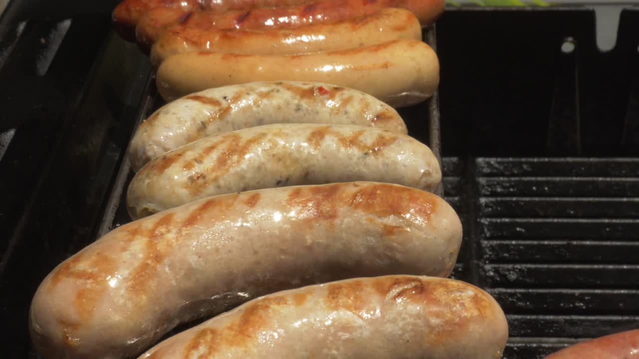 barbacoa día soleado salchichas comida a la parrilla hombres colocando salchichas en el fuego de la barbacoa cocina cruda