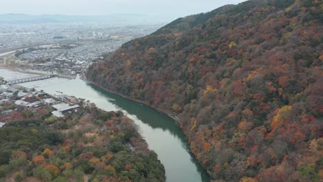 Kyoto-Luftschwenk-Von-Arashiyama-Und-Der-Togetsu-Kyo-Brücke,-Um-Die-Stadt-Im-Hintergrund-Sichtbar-Zu-Machen