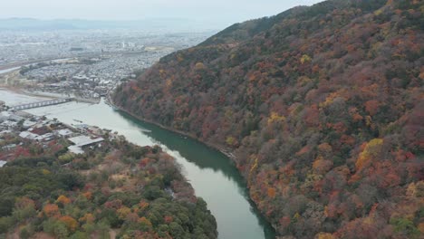 Panorámica-Aérea-De-Kyoto-Desde-Arashiyama-Y-El-Puente-Togetsu-kyo-Para-Revelar-La-Ciudad-En-El-Fondo