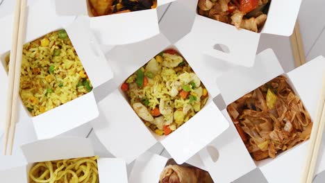 Asian-take-away-or-delivery-food-concept--Paper-boxes-placed-on-white-wooden-table