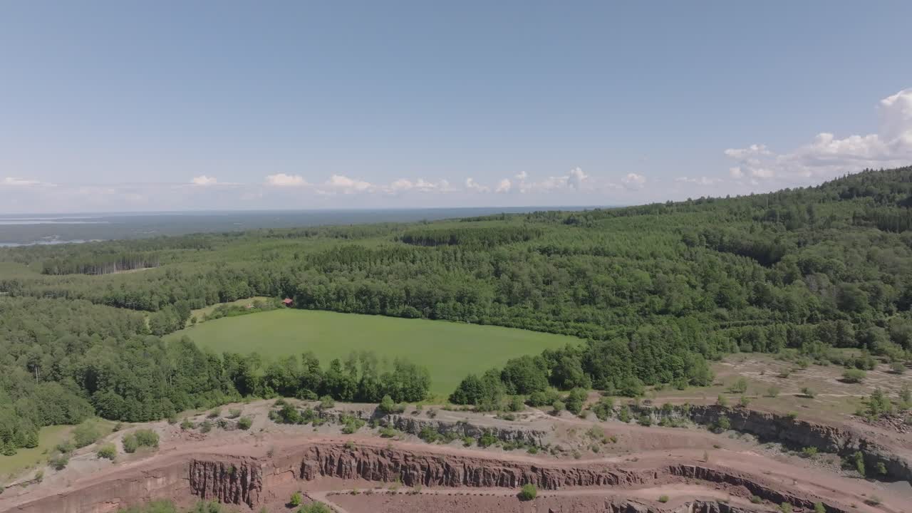 스웨덴 할레키스 에 있는 킨쿨레 스텐브로트 (kinnekulle stenbrott) 의 대규모 광산 근처 에 있는 울창 한 숲