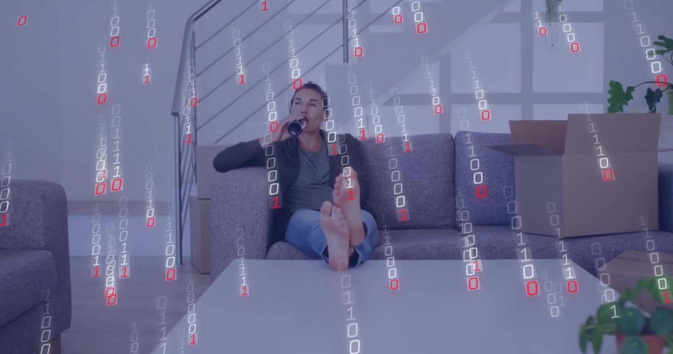 Woman sipping bottle on sofa beside box after binary code drifting across tech-themed living room