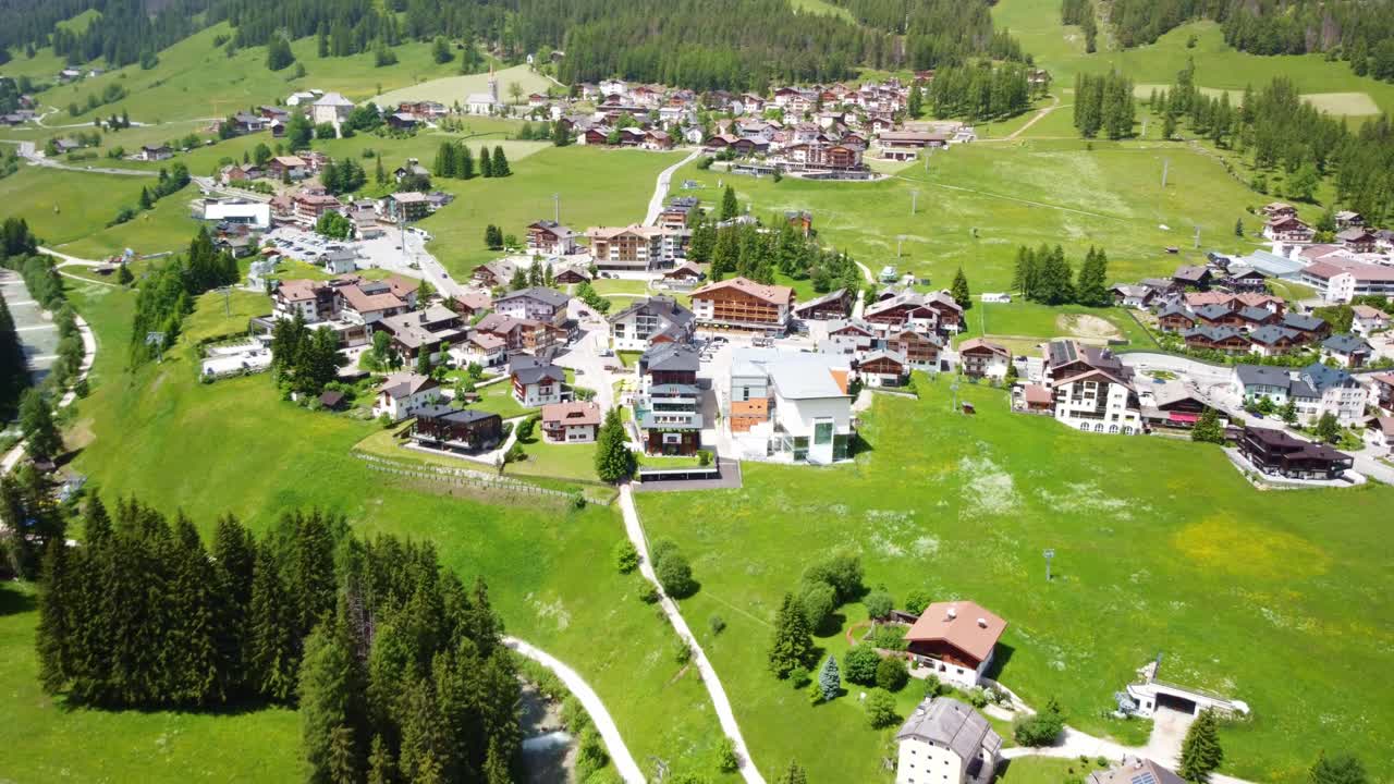 Aerial View of a Charming Alpine Village Nestled in a Lush Green Valley
