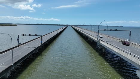 drone estableciendo empuje en la toma del puente conmemorativo ted smoot, cámara volando entre ambos carriles del puente, siguiendo coches mientras conducen a través del puente