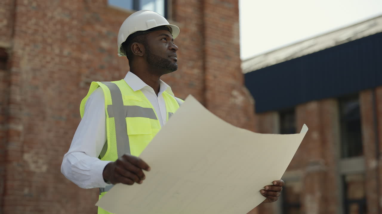 Architect reviewing blueprints at a construction site