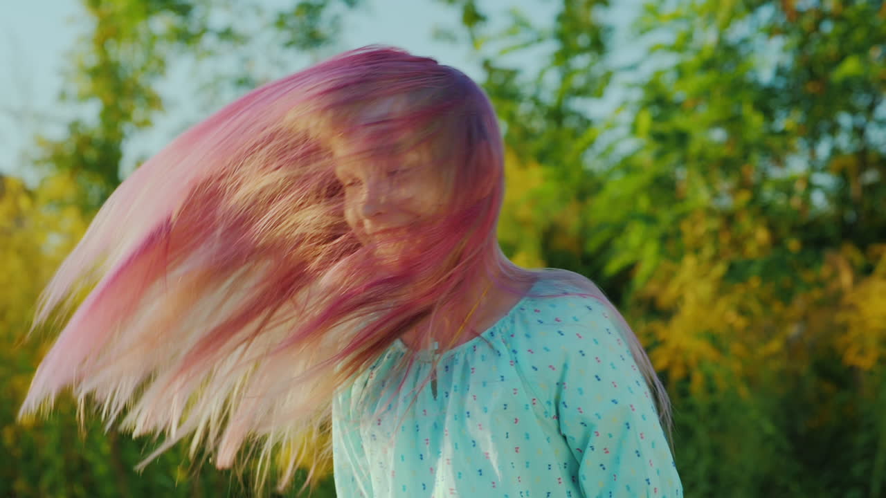 그녀의 분홍색 긴 머리를 가지고 노는 멋진 소녀